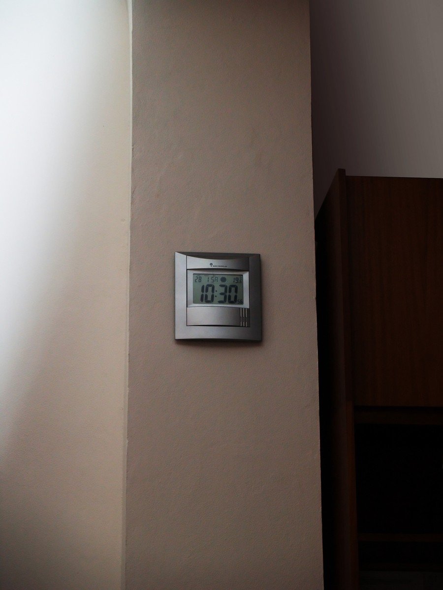 a small wall clock with a temperature displayed on the wall