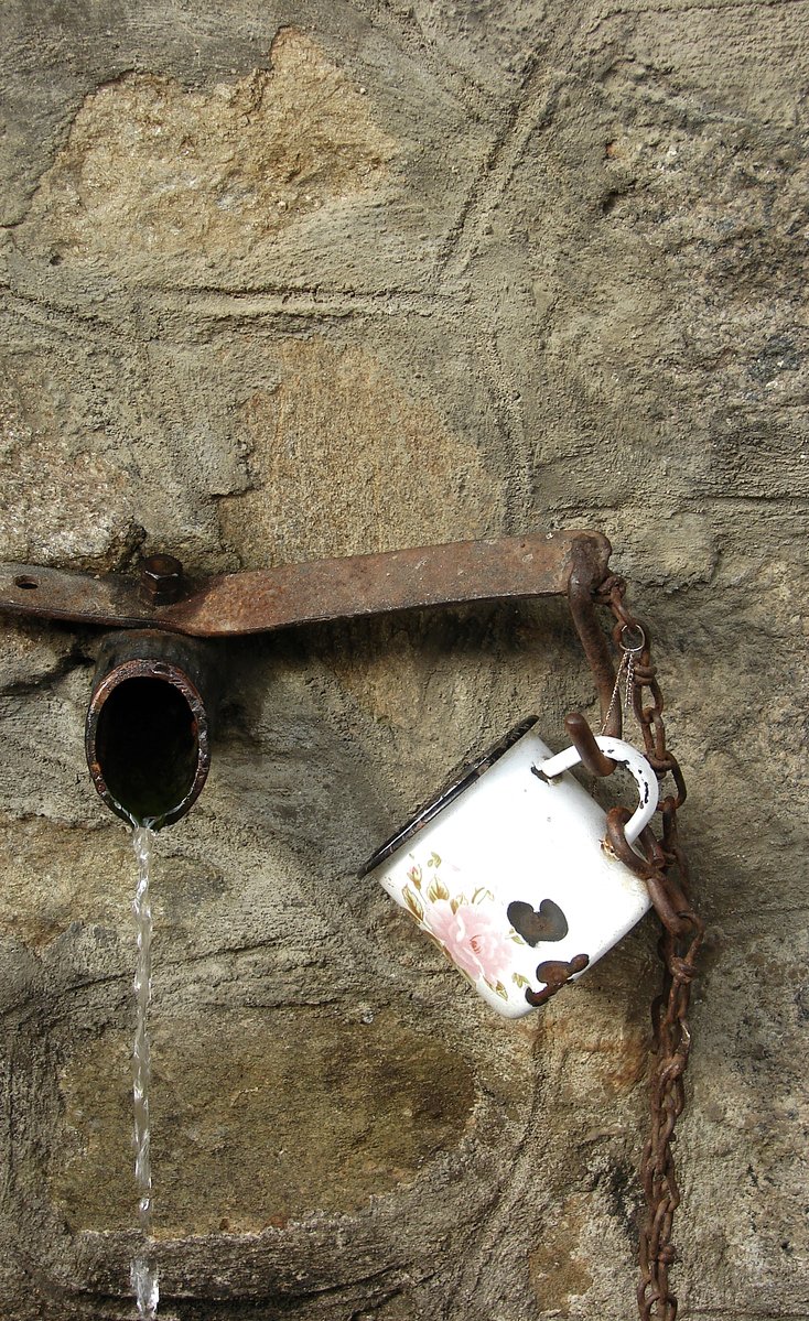 a water spouter attached to a rusty pipe