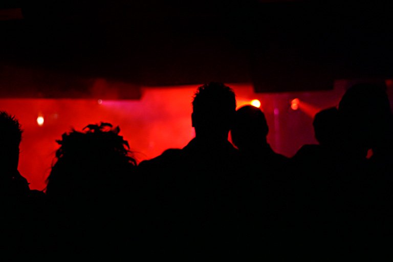 silhouettes of people in front of red lights
