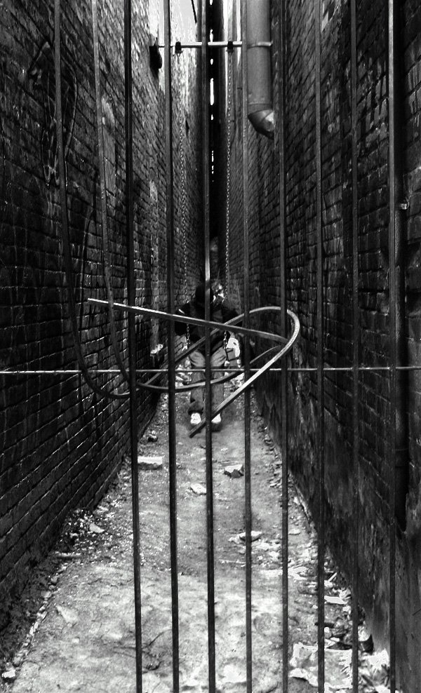 black and white po of an alleyway with bars