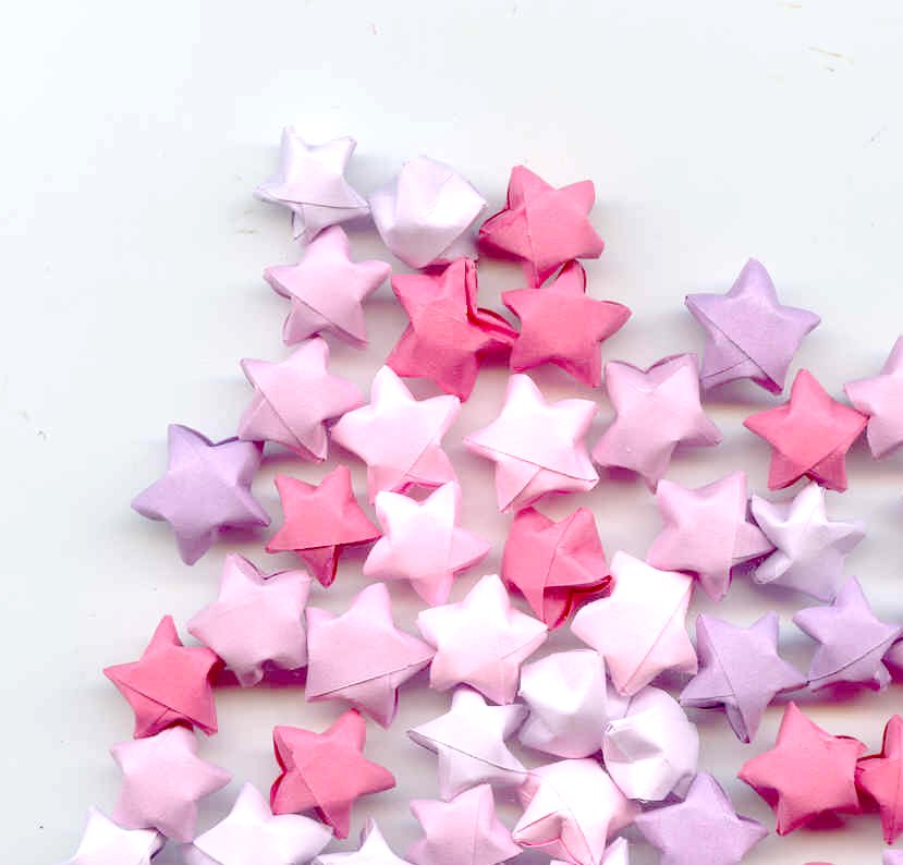 there are many different sized pink and purple paper stars