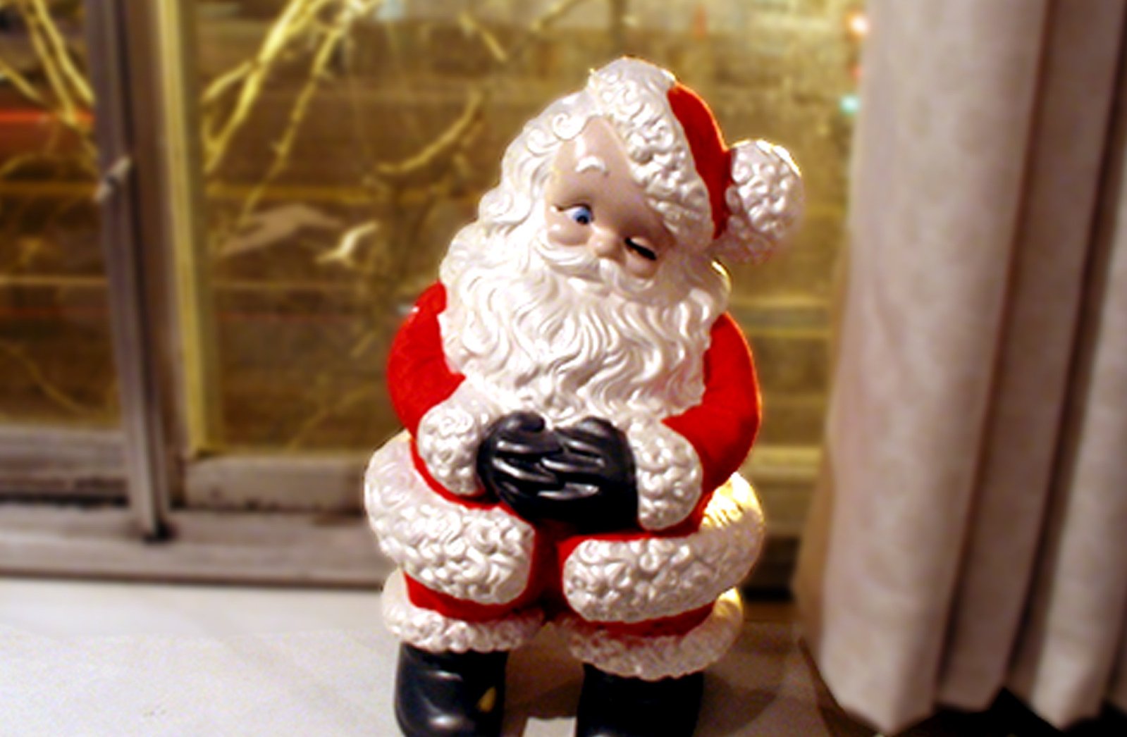 a white and red santa figurine on a windowsill