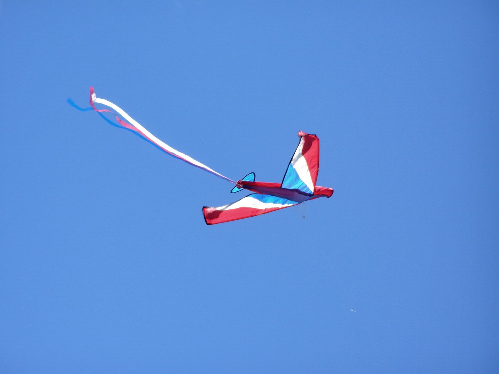 the kite is flying high in the blue sky