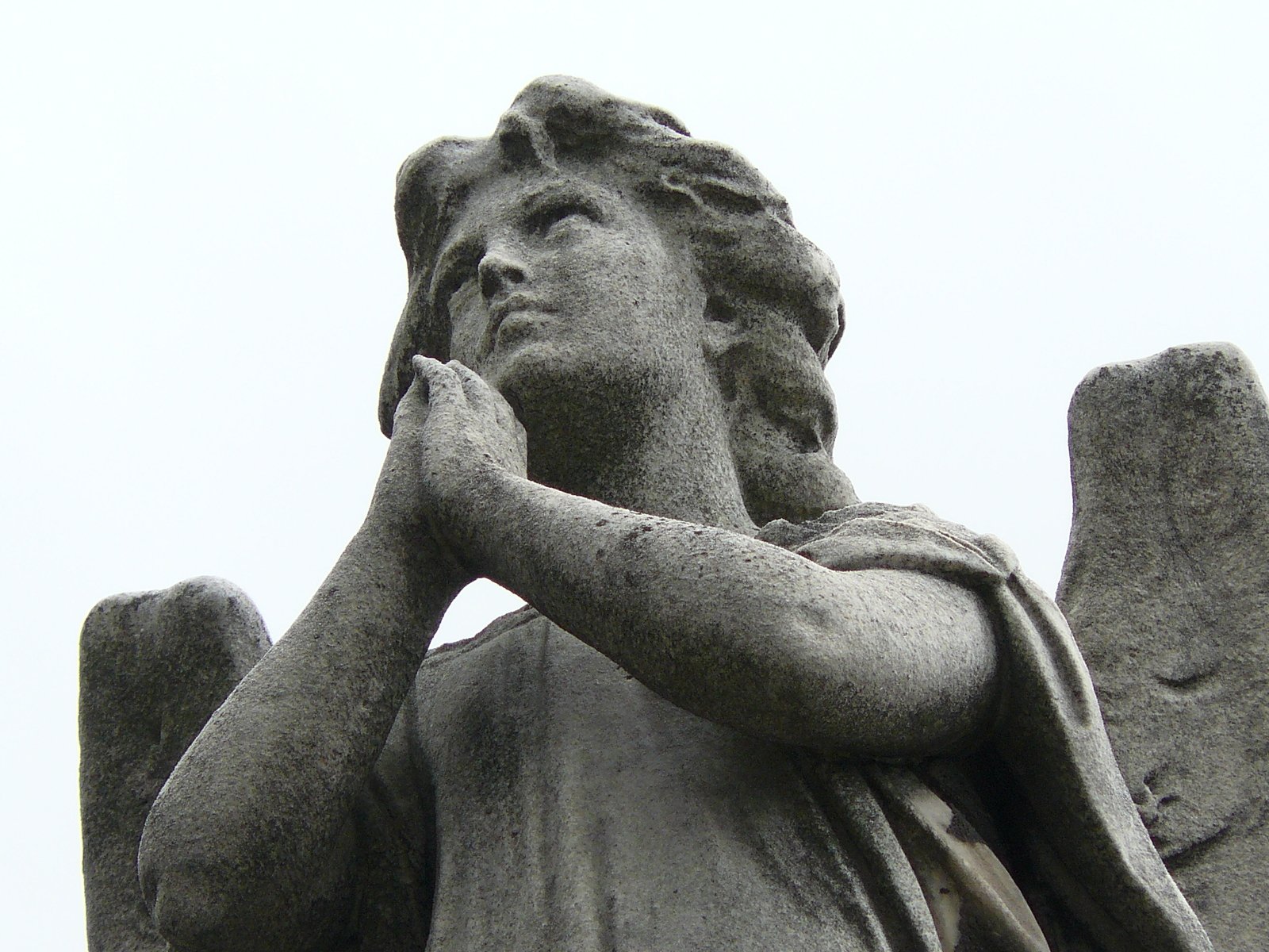 a statue has wings and is holding his arm over his temple