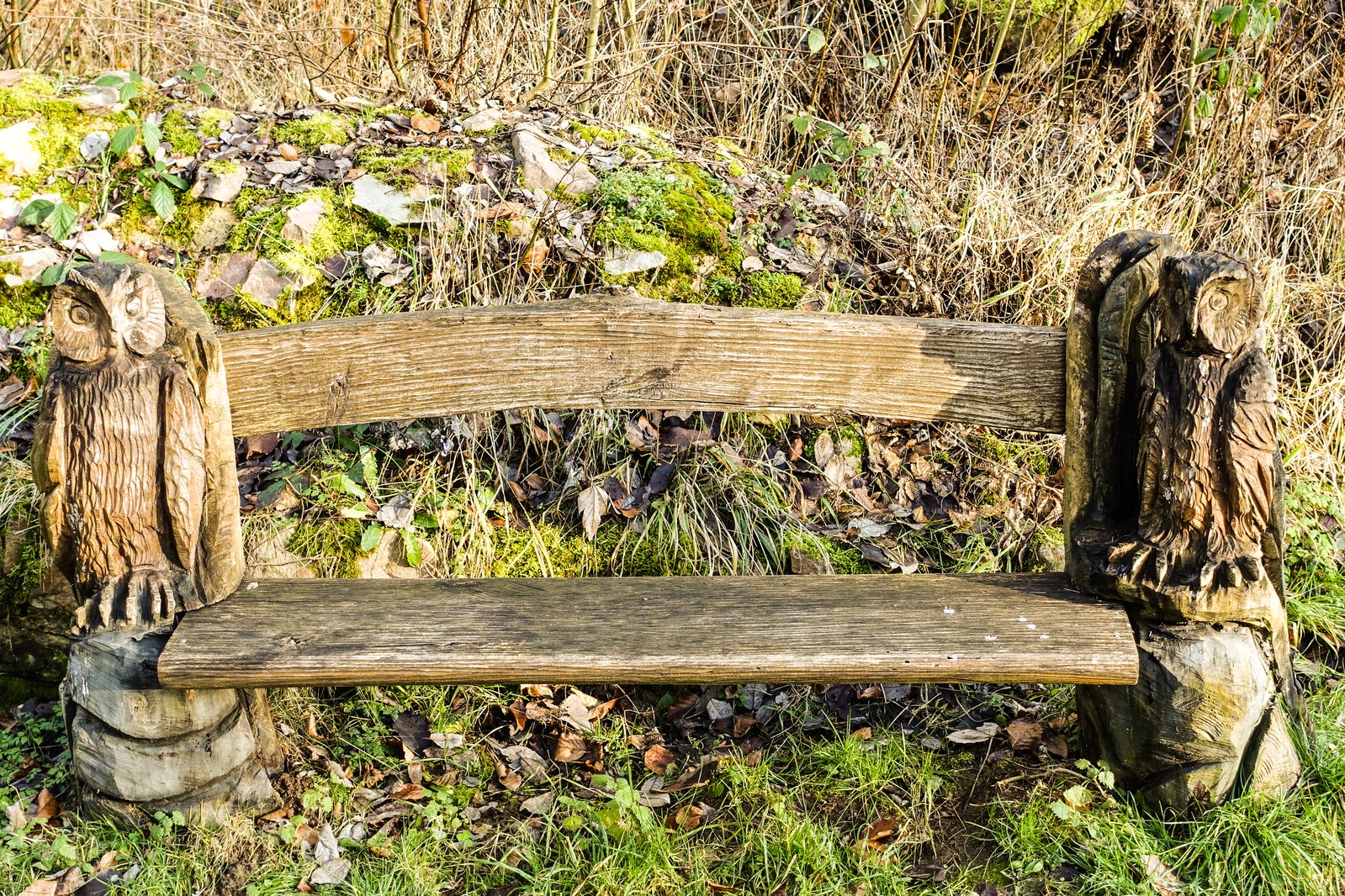 old wooden bench with two wooden birds on it