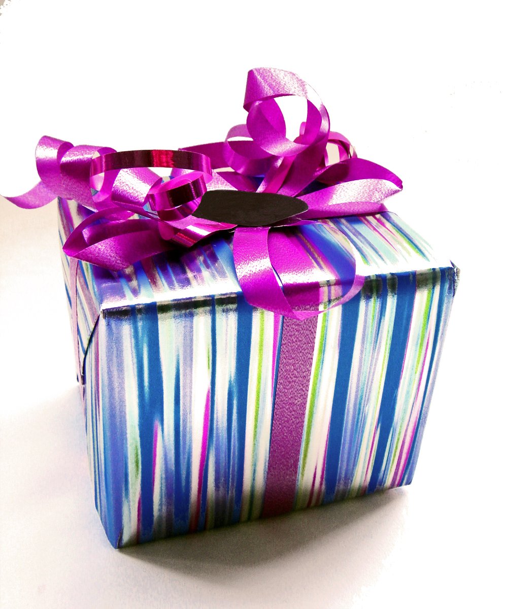 there is a colorful striped gift box with a purple ribbon on it