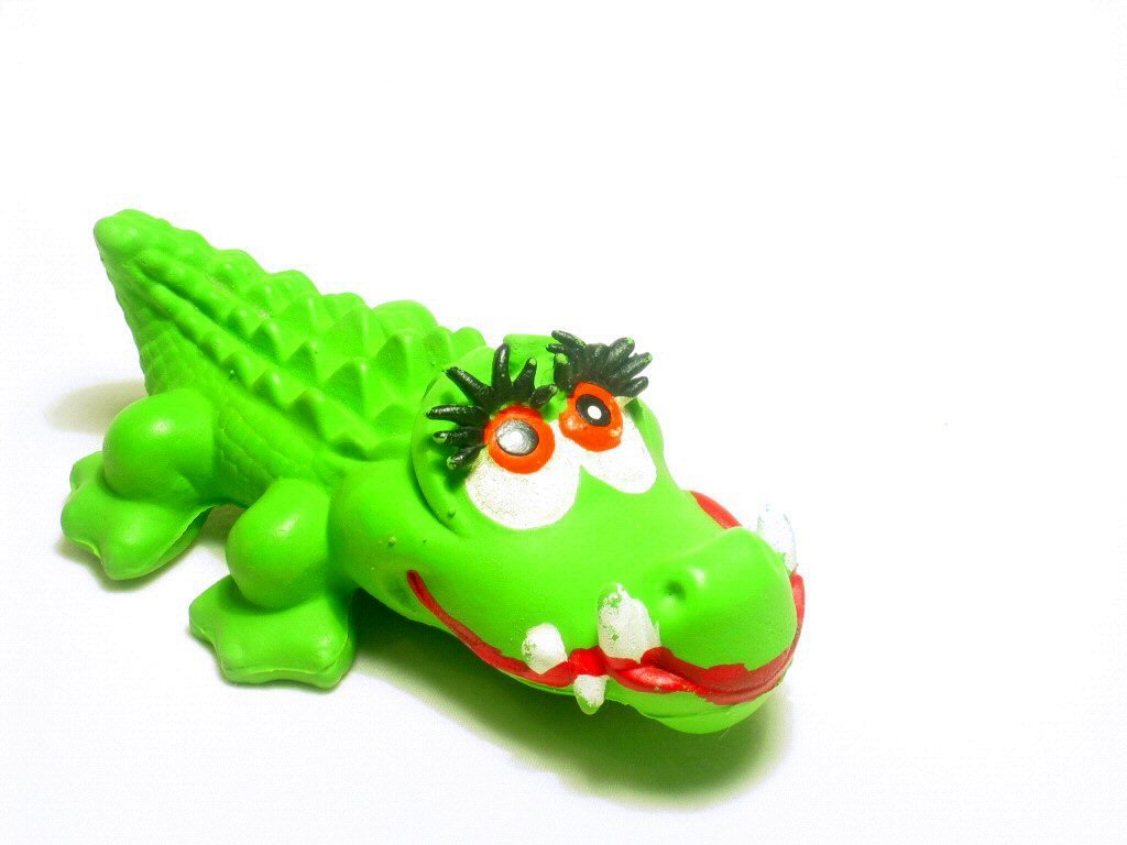the toy alligator is green and has large eyes