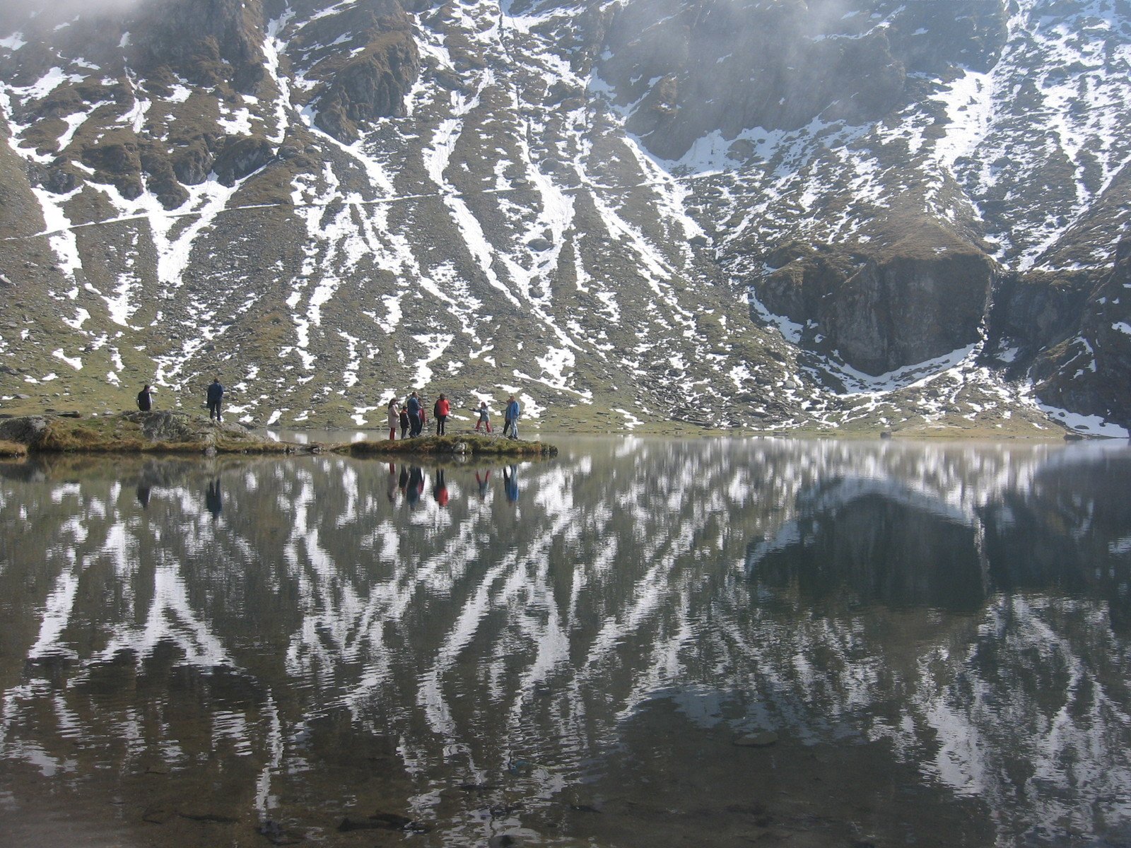 a group of people standing around a lake