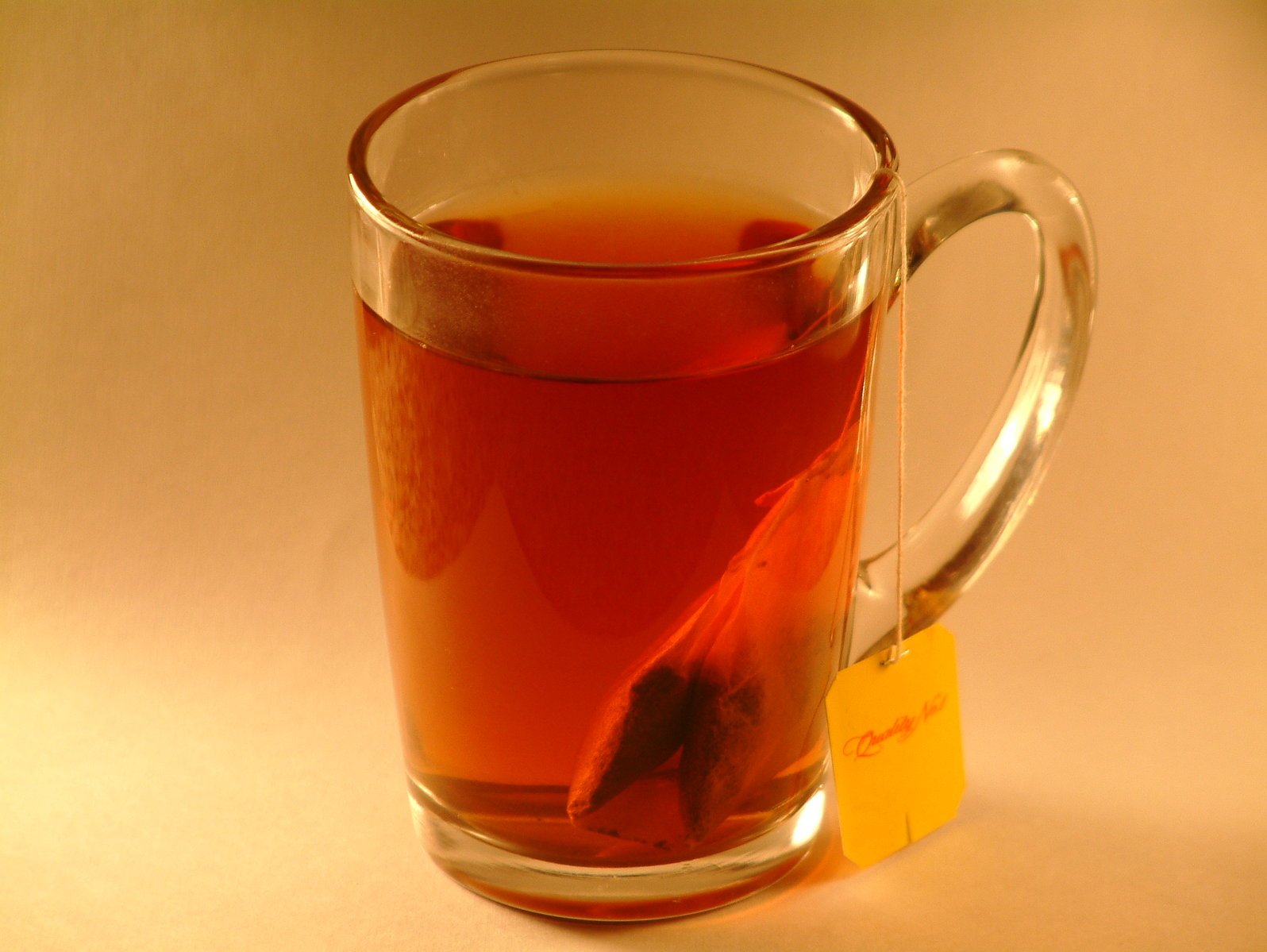 a glass mug filled with tea next to a yellow label