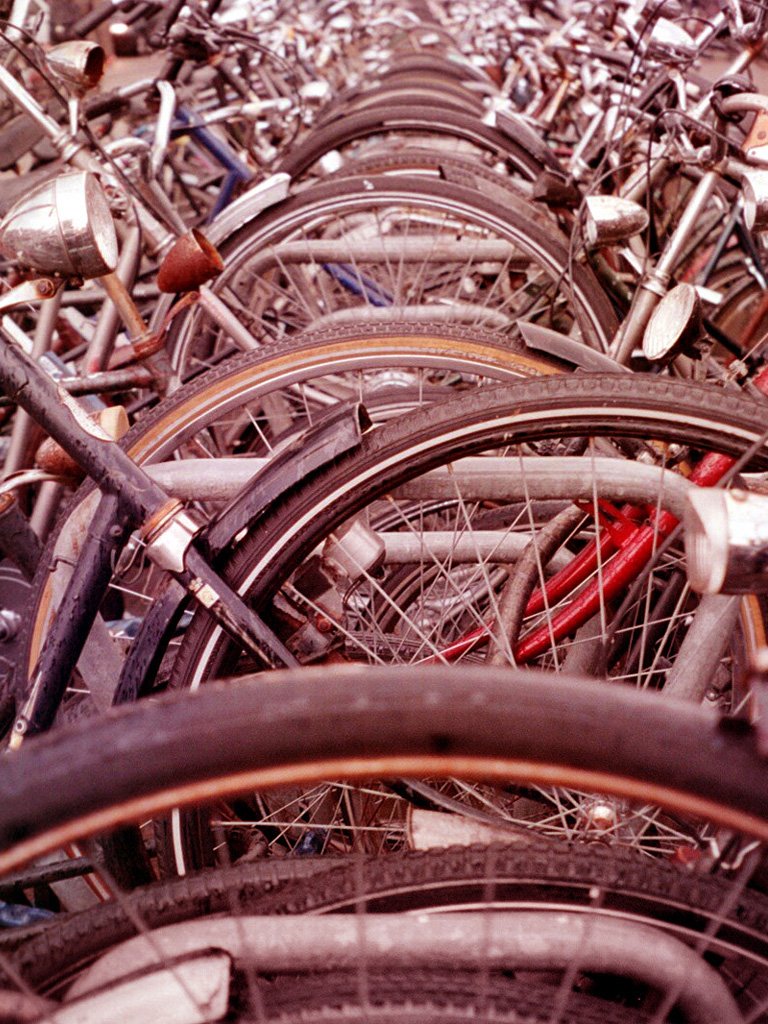 a large pile of bikes parked next to each other