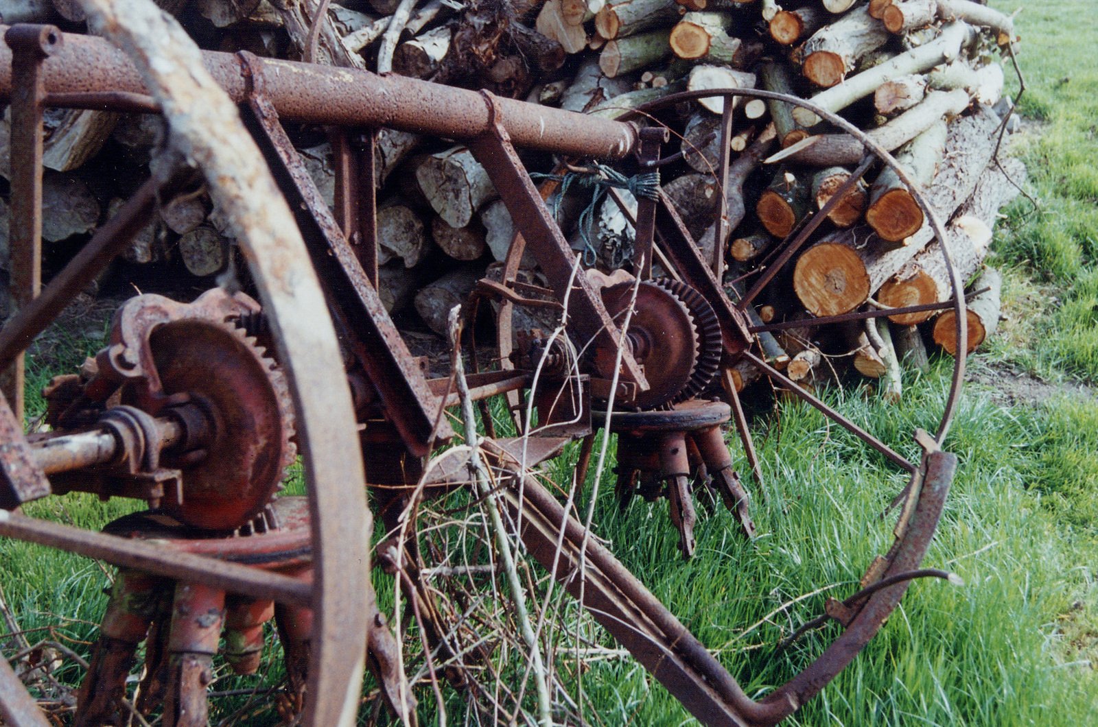 an old bicycle is standing next to firewood