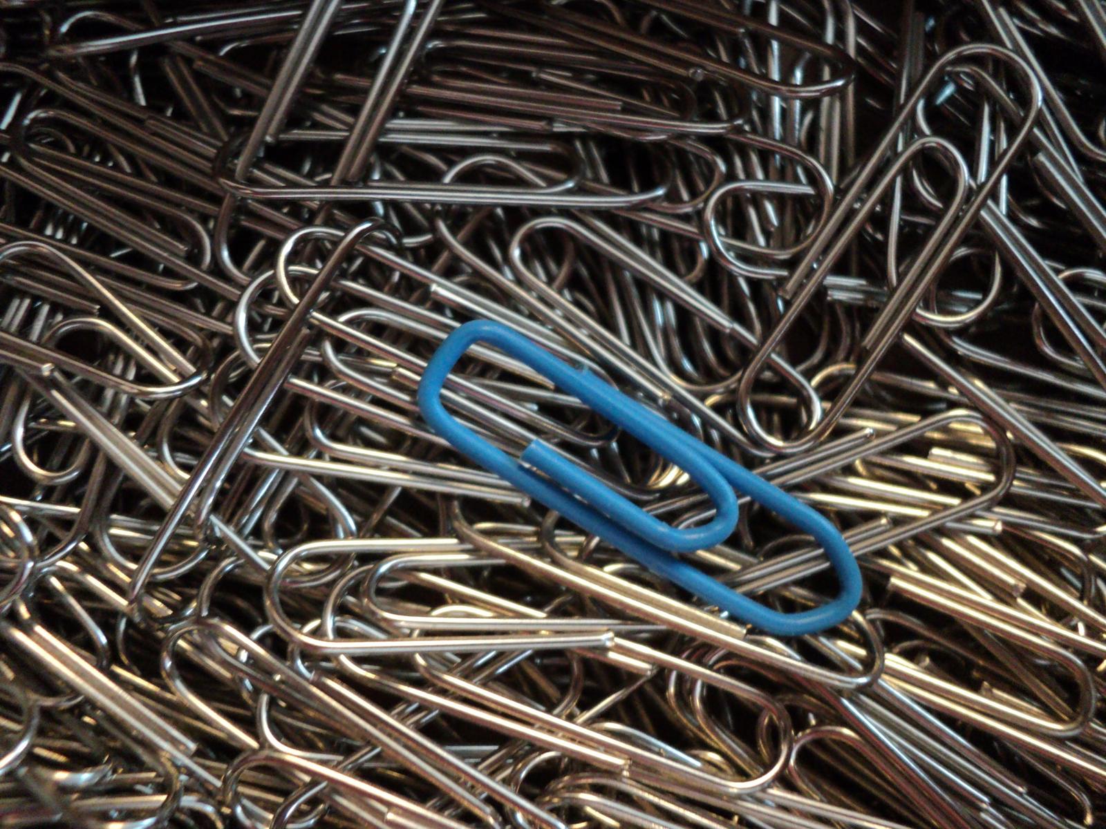 a blue linked ring amongst lots of different metal pieces