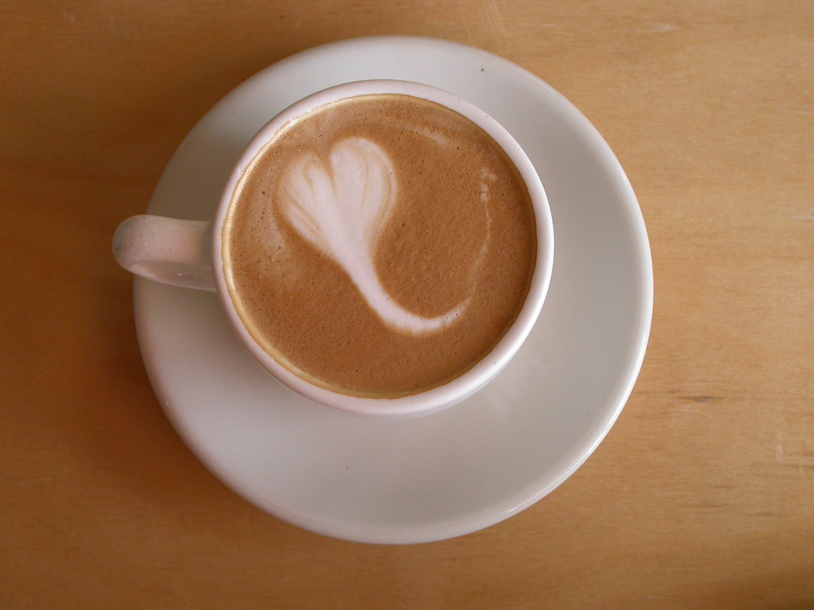 there is a cup of coffee with a heart design in it