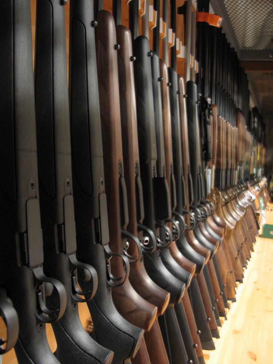 several rows of guns displayed on a rack