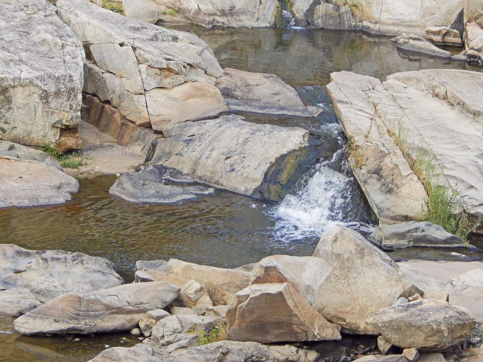 there is rocks in the water and a man standing on them