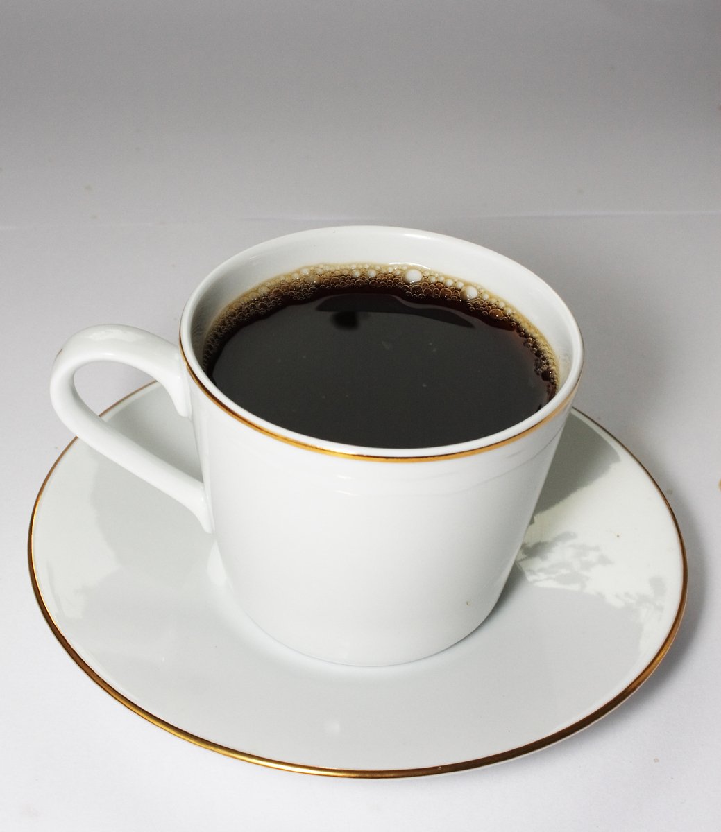 a small coffee cup filled with black liquid