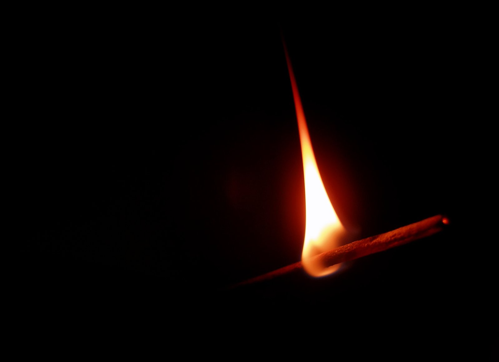 the candle is glowing and red against the black background