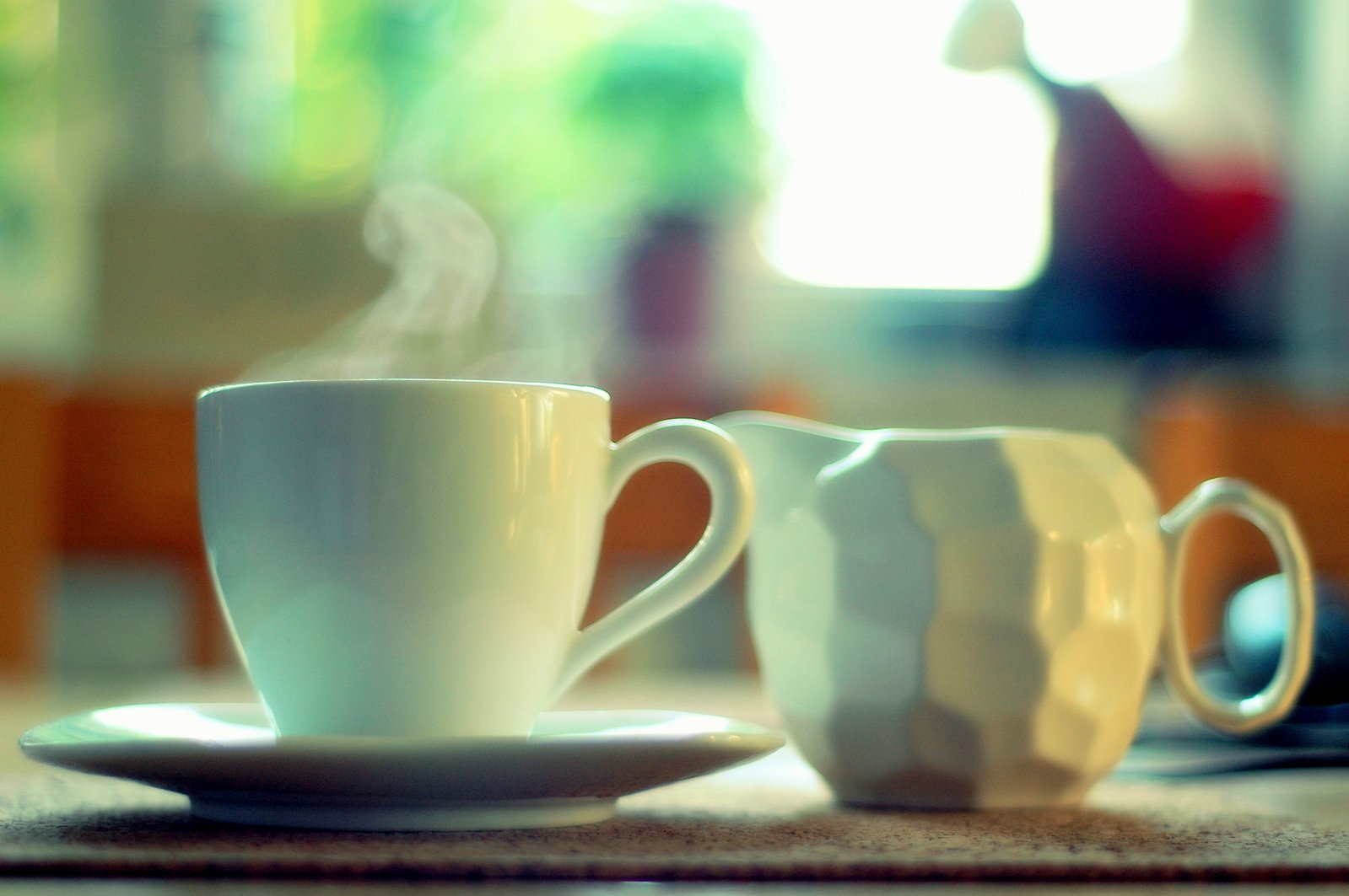 two white cups on a table with their steaming