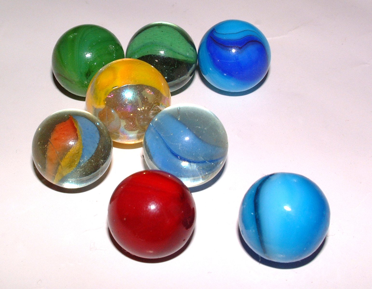 some glass marbles sitting on a white surface