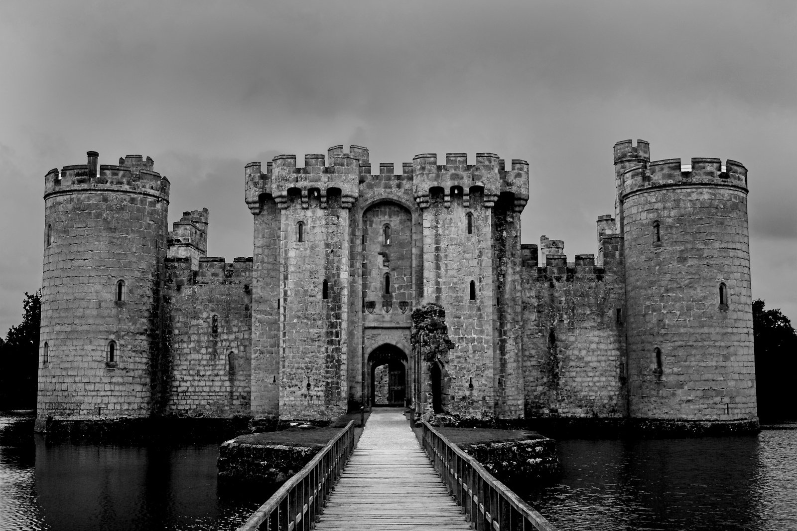 a black and white po of a bridge leading to some medieval castles