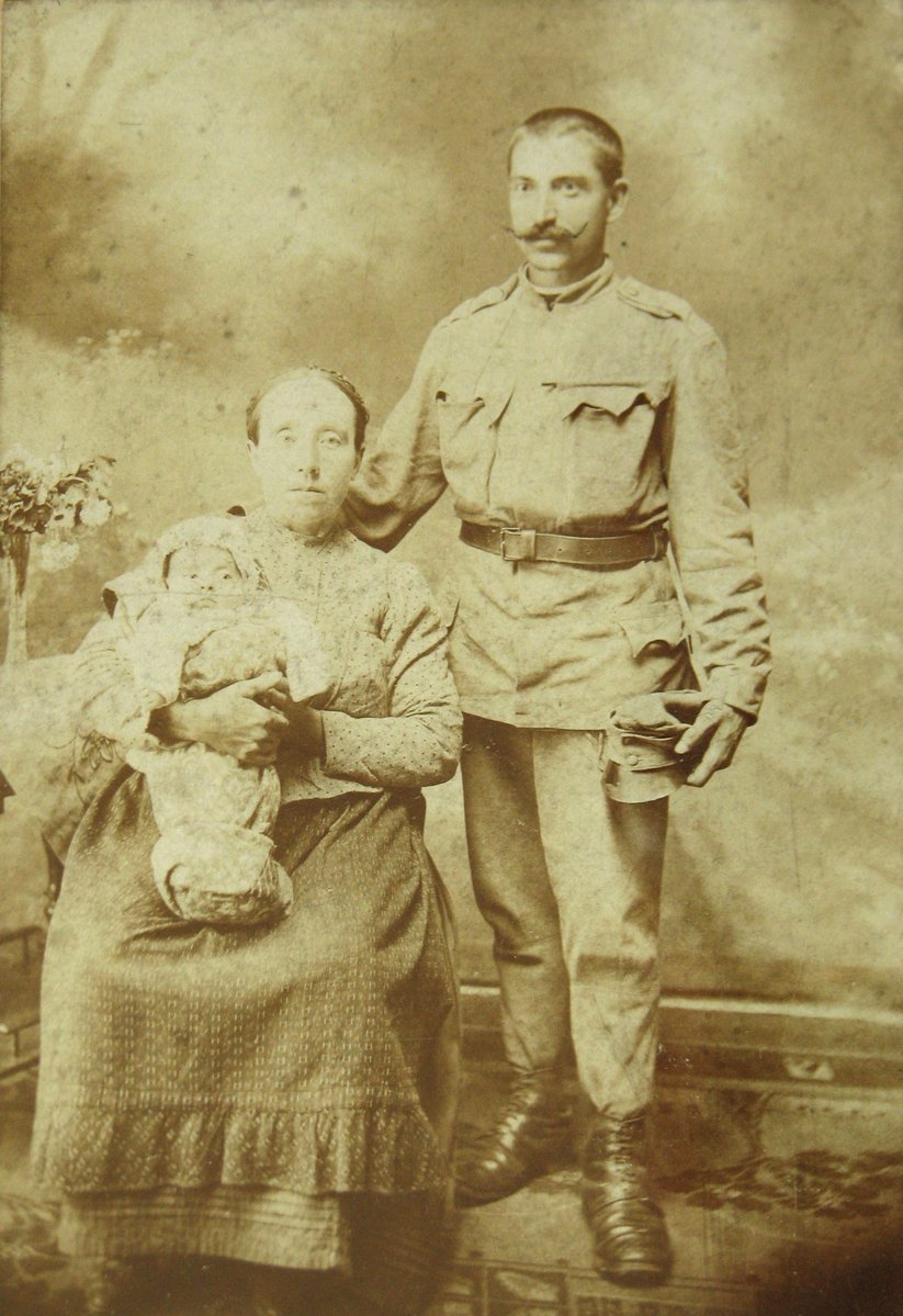 an old - fashioned po of a man and woman holding a baby