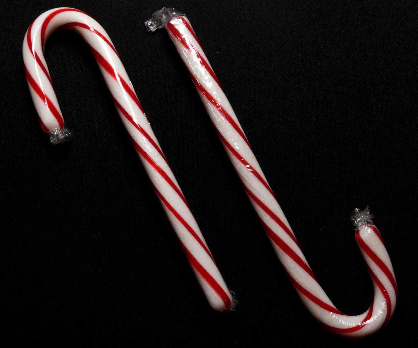 two candy canes with melted red stripes next to each other