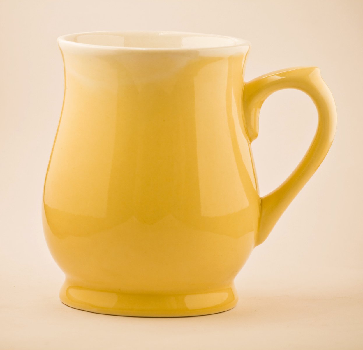 a yellow jug sitting on a table next to another