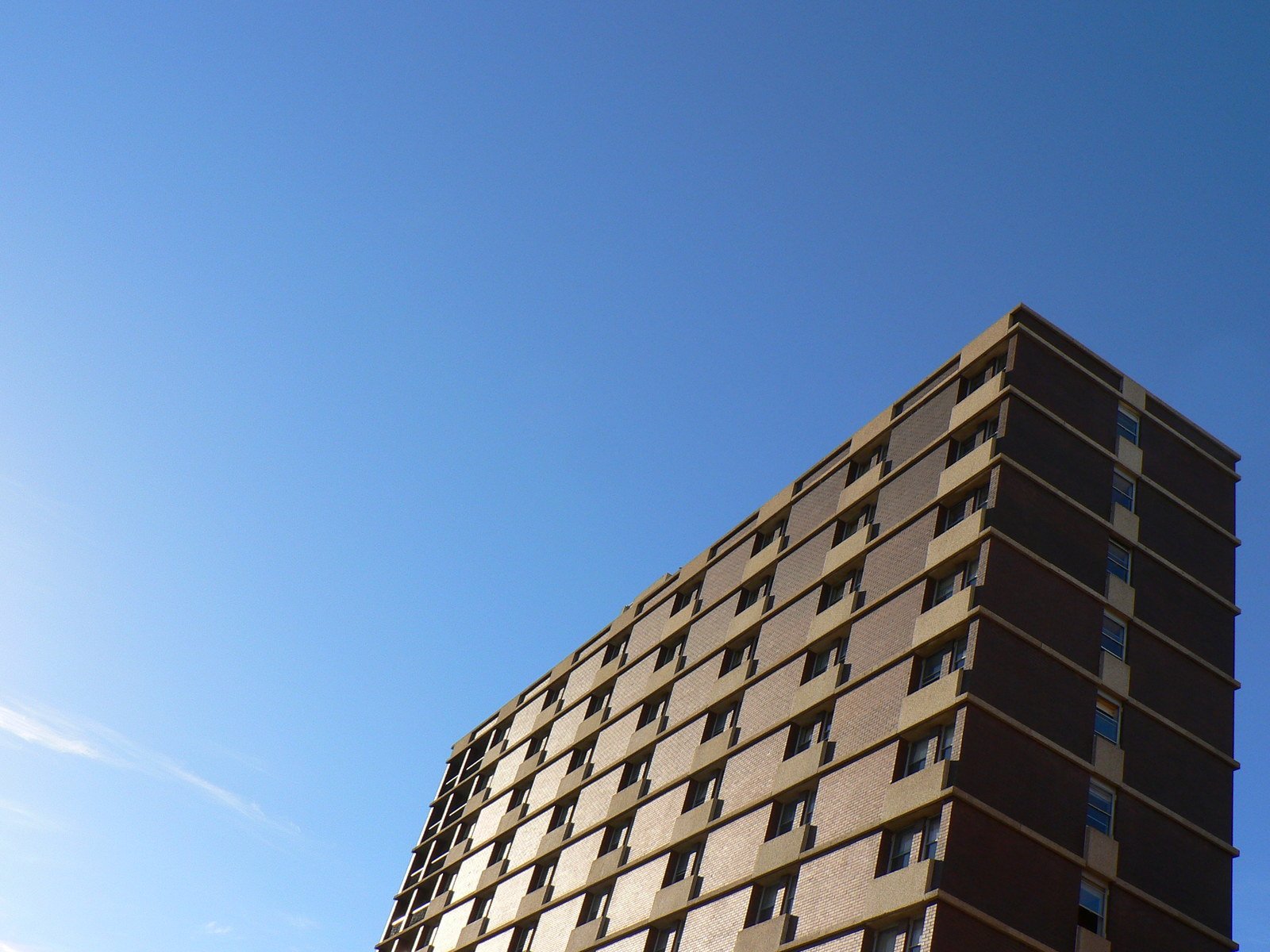 a tall building on the corner of a clear blue sky