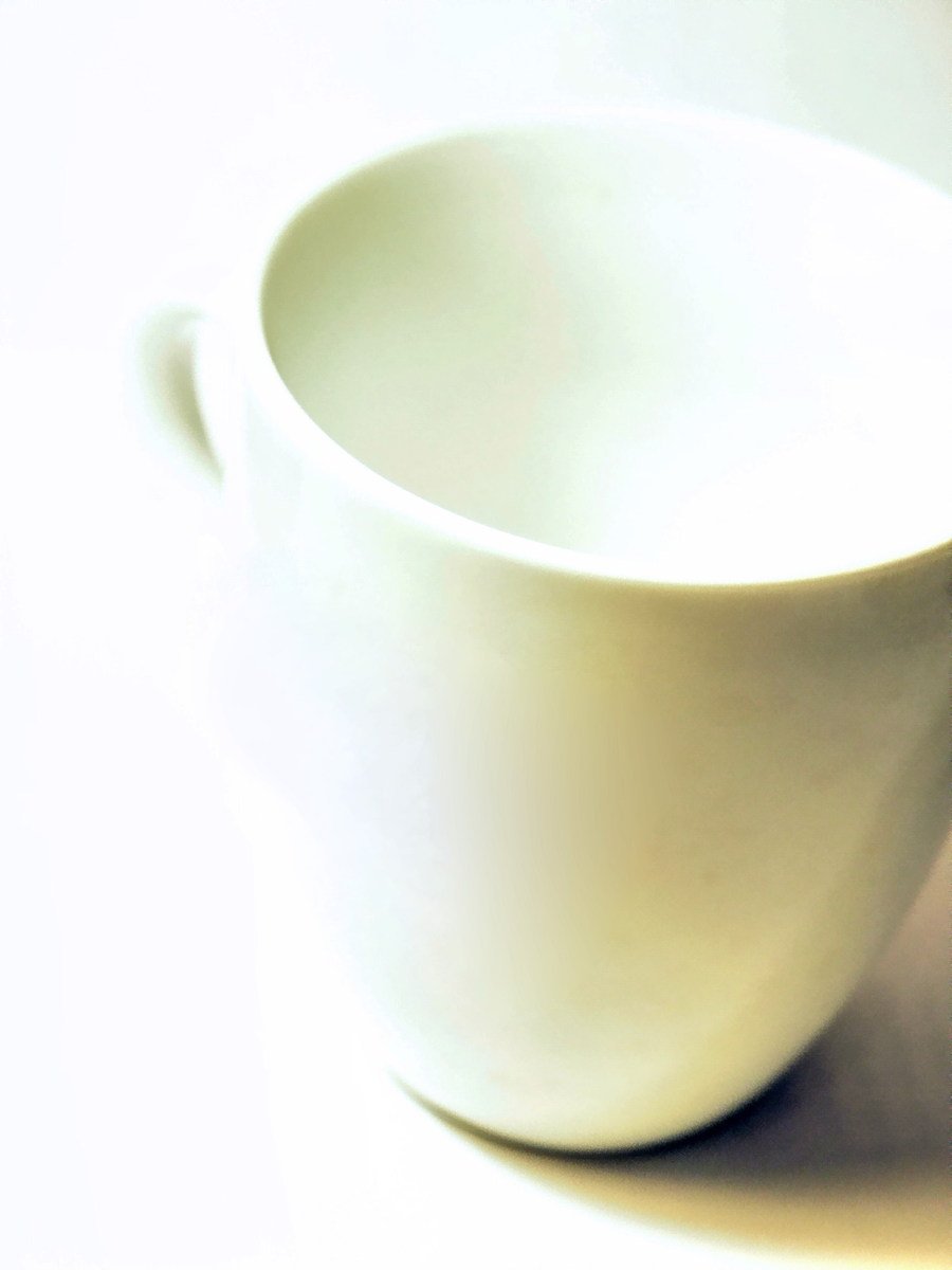 a white coffee cup is shown on a table