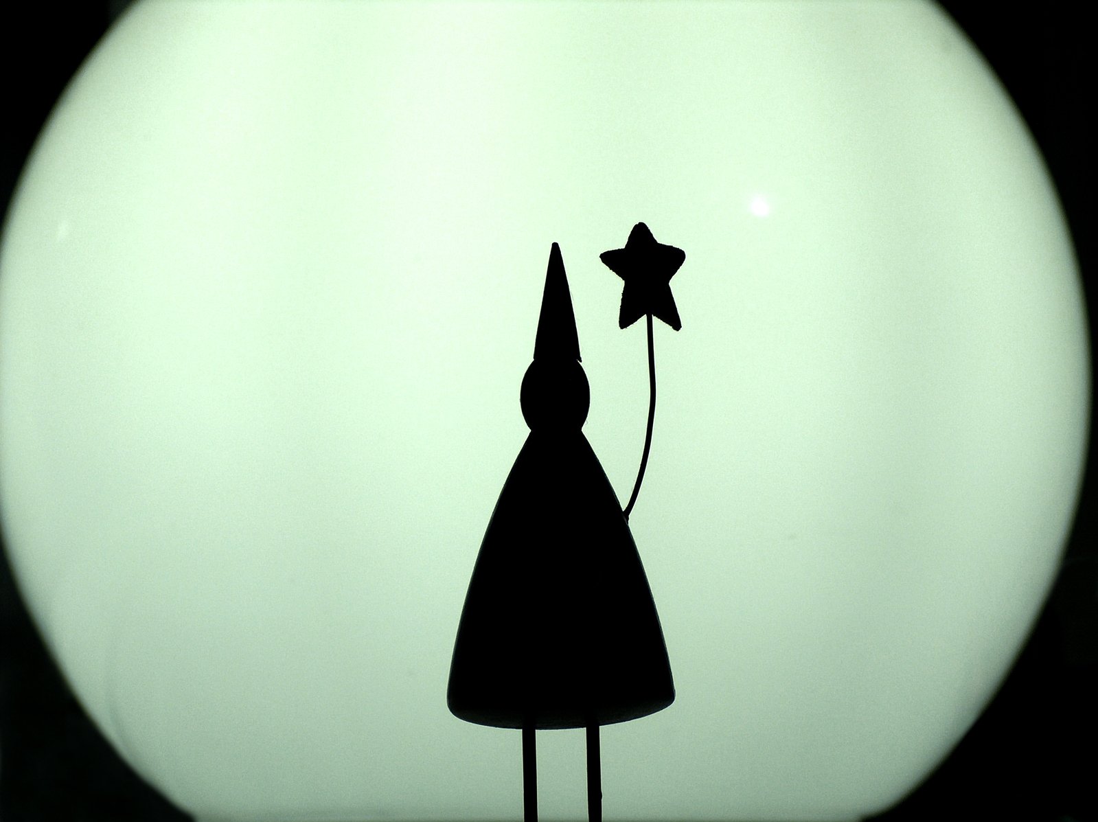 black silhouette of figure holding up star shaped balloon