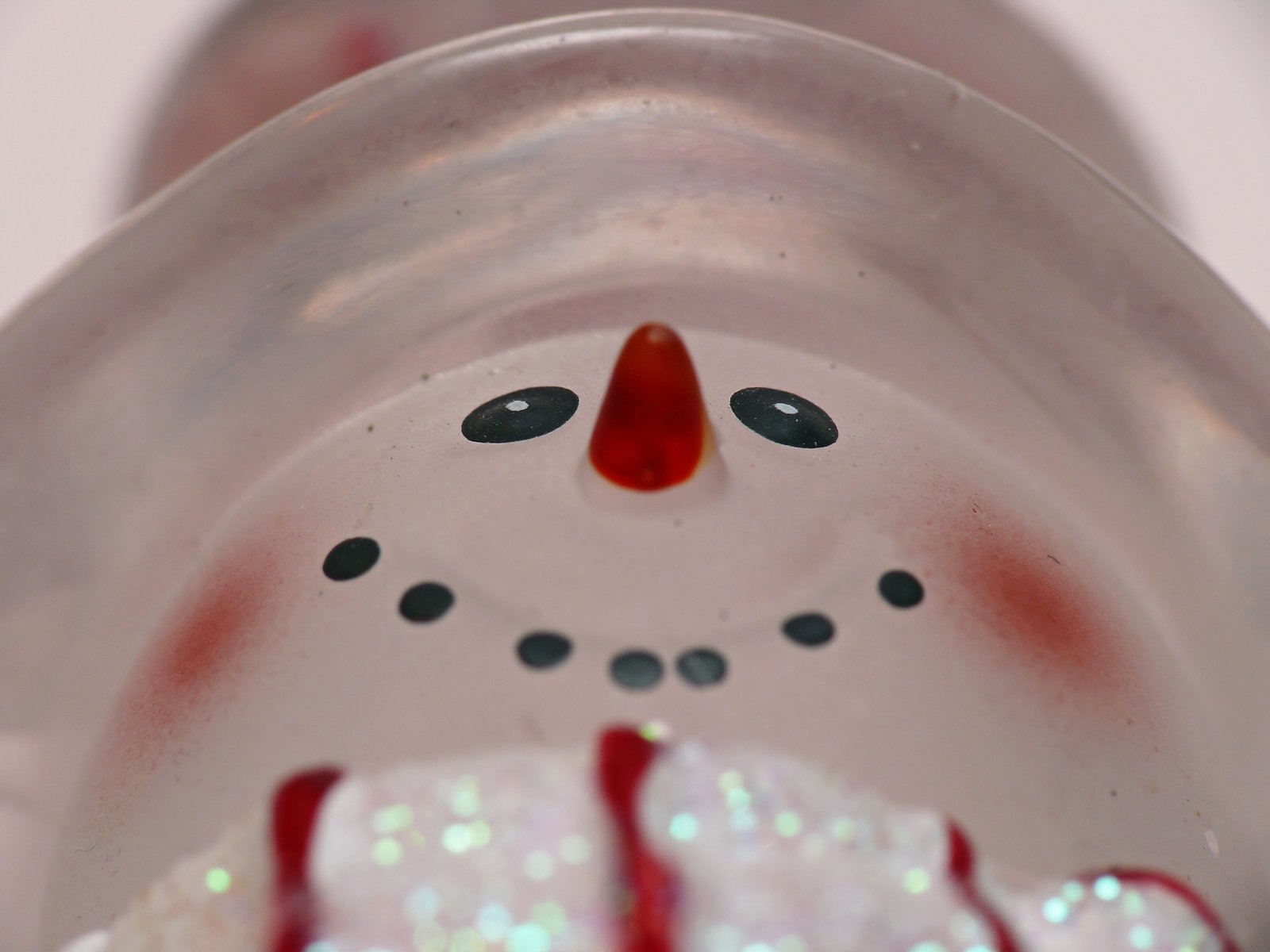 a close up of a frosting cup with a face drawn on it