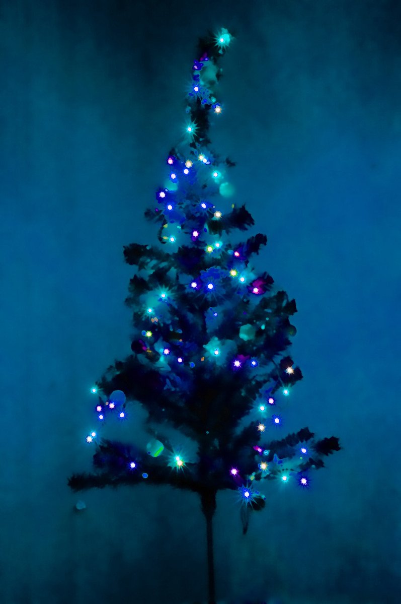 the small blue christmas tree has several bright lights