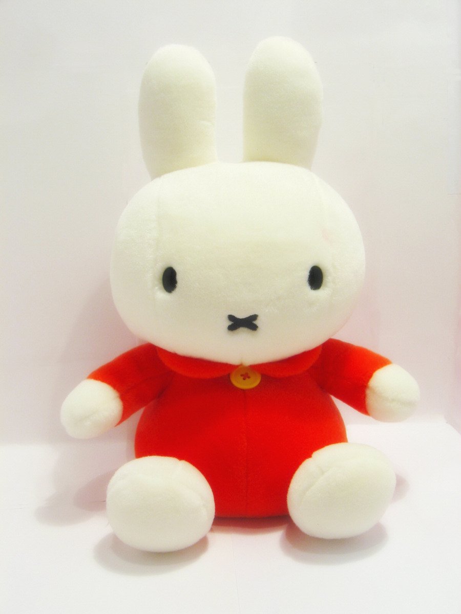 a white stuffed bunny wearing a red outfit