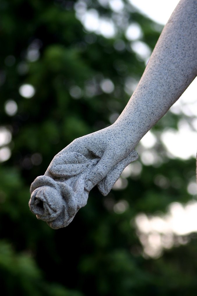 a statue holding a piece of cloth in it's palm