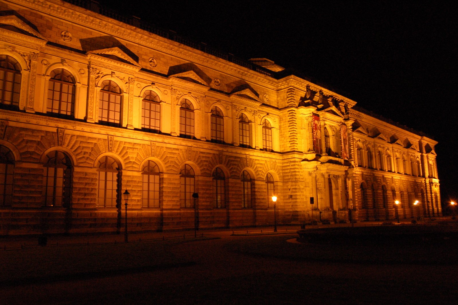 the front side of an old building lit up at night