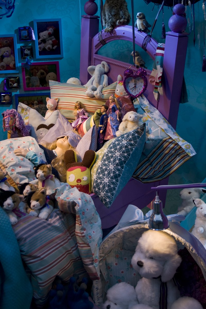 a pile of stuffed bears sitting inside of a purple and blue room
