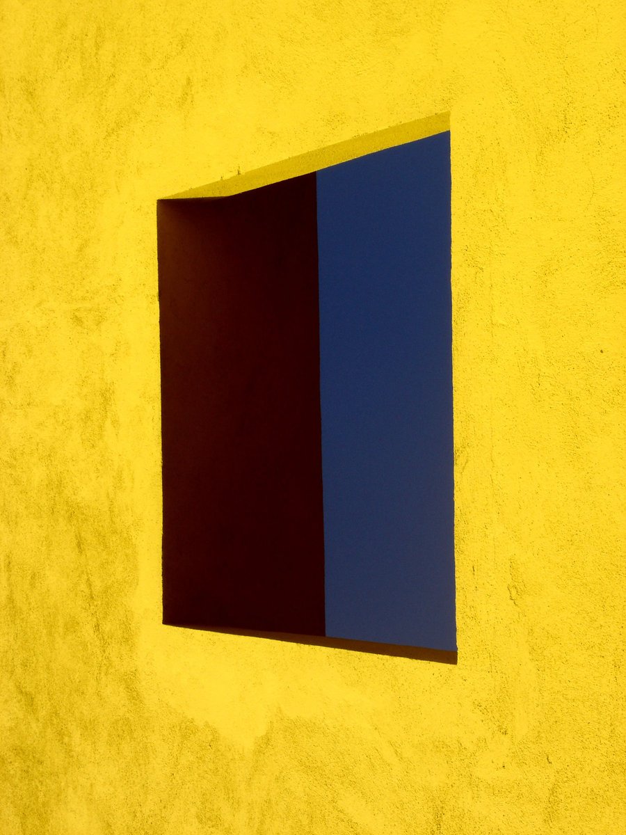 a blue and yellow background of a yellow building