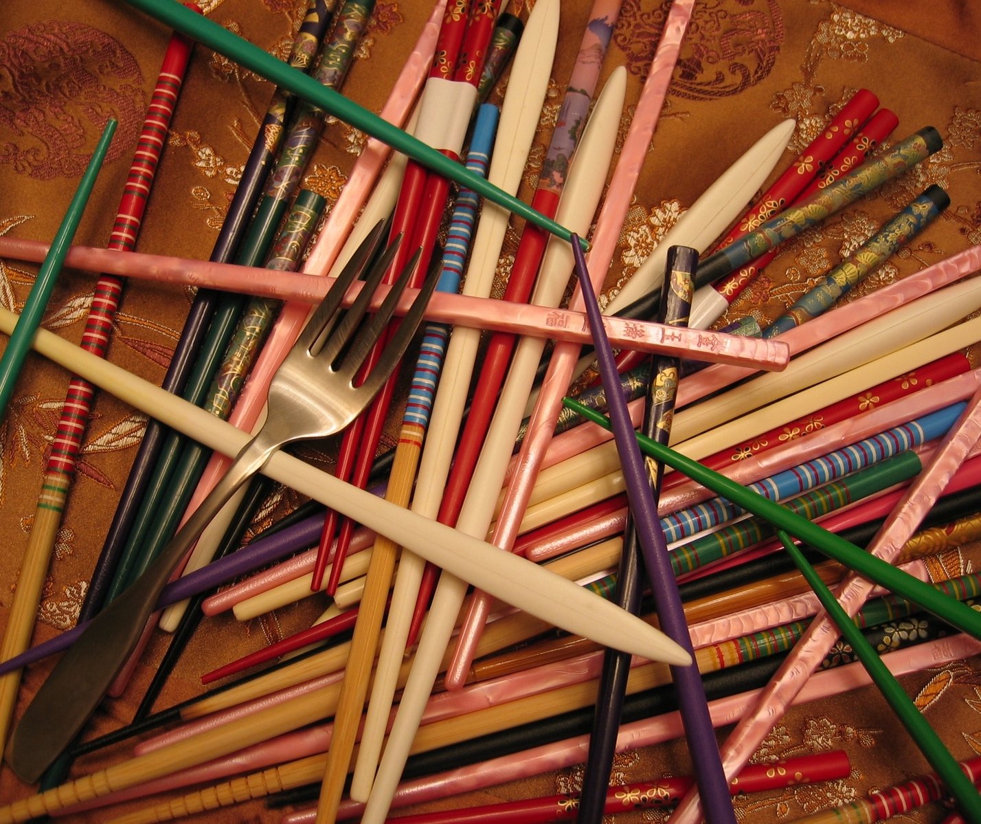 a bunch of colored pencils and some forks