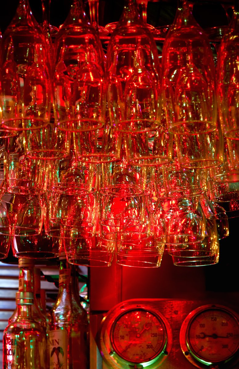 many wine glasses are set up beside different bottles