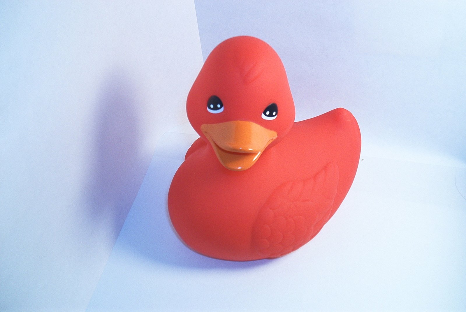 a small toy rubber duck sits on the paper