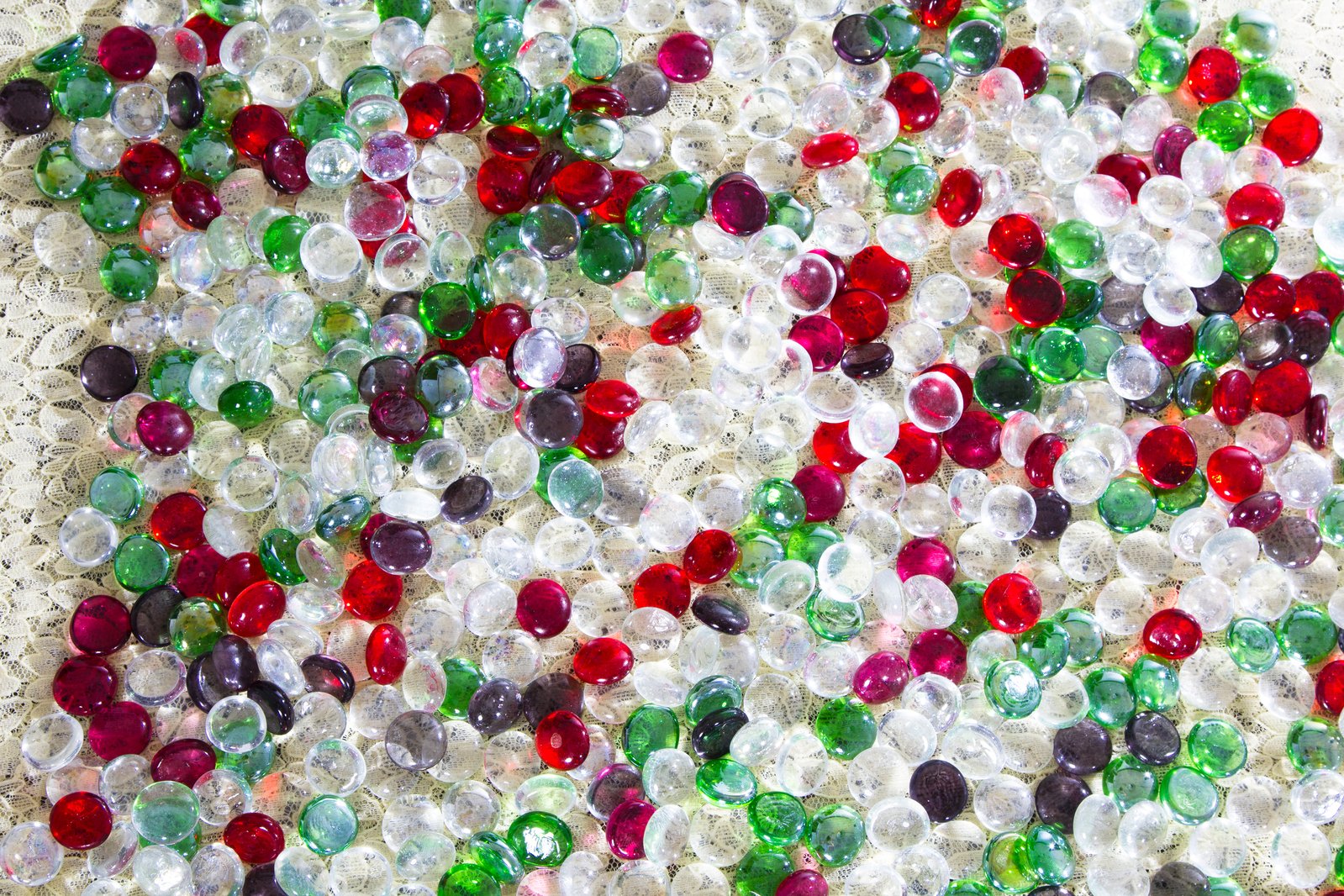 close up of red, green and black pearls arranged in a circular pattern