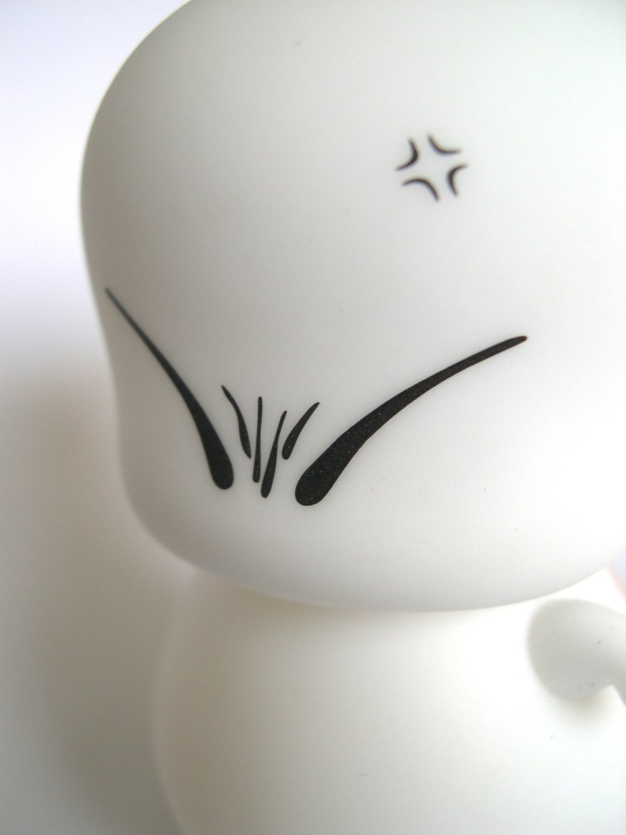 a ceramic figurine of the face of a white kitty