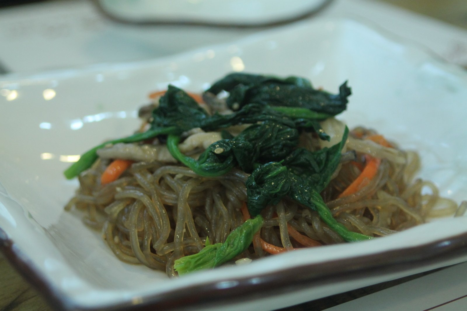 a plate of vegetables and noodles is displayed