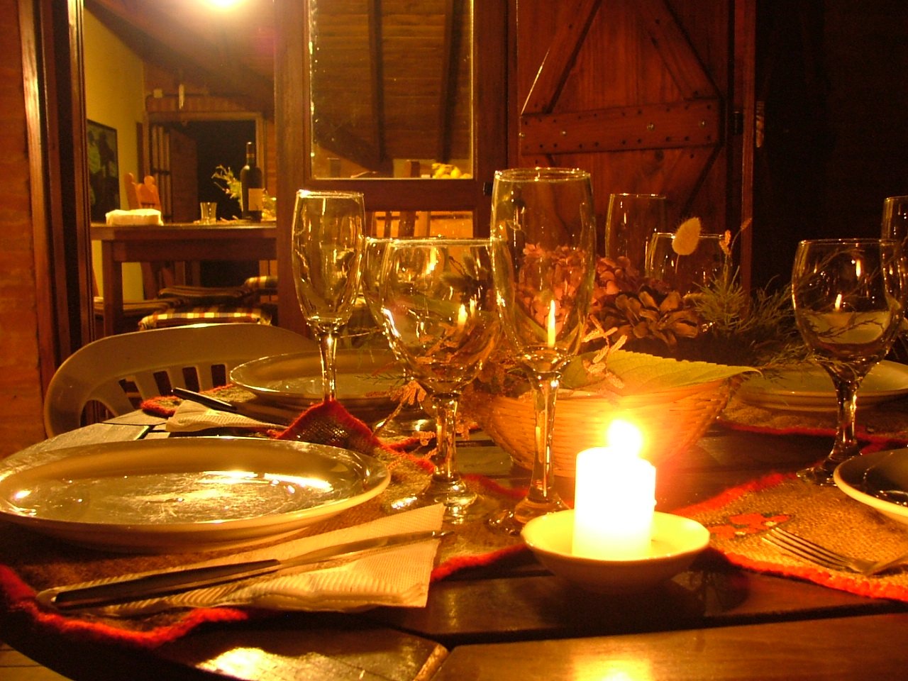 candlelit dinner table with dishes and candlestick