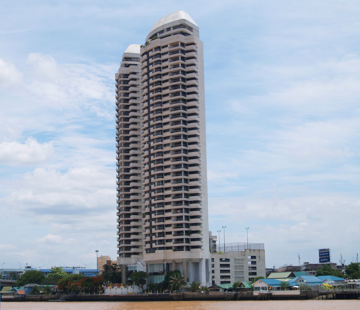 there is a tall white building by the water