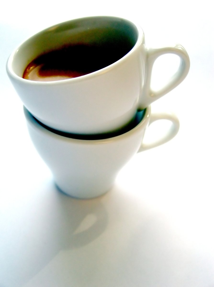 two coffee cups are stacked in a neat stack