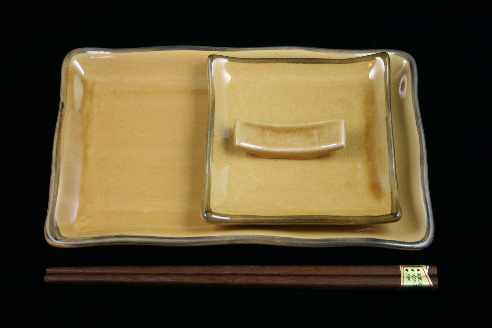 two different sized chopsticks in a dish on black background