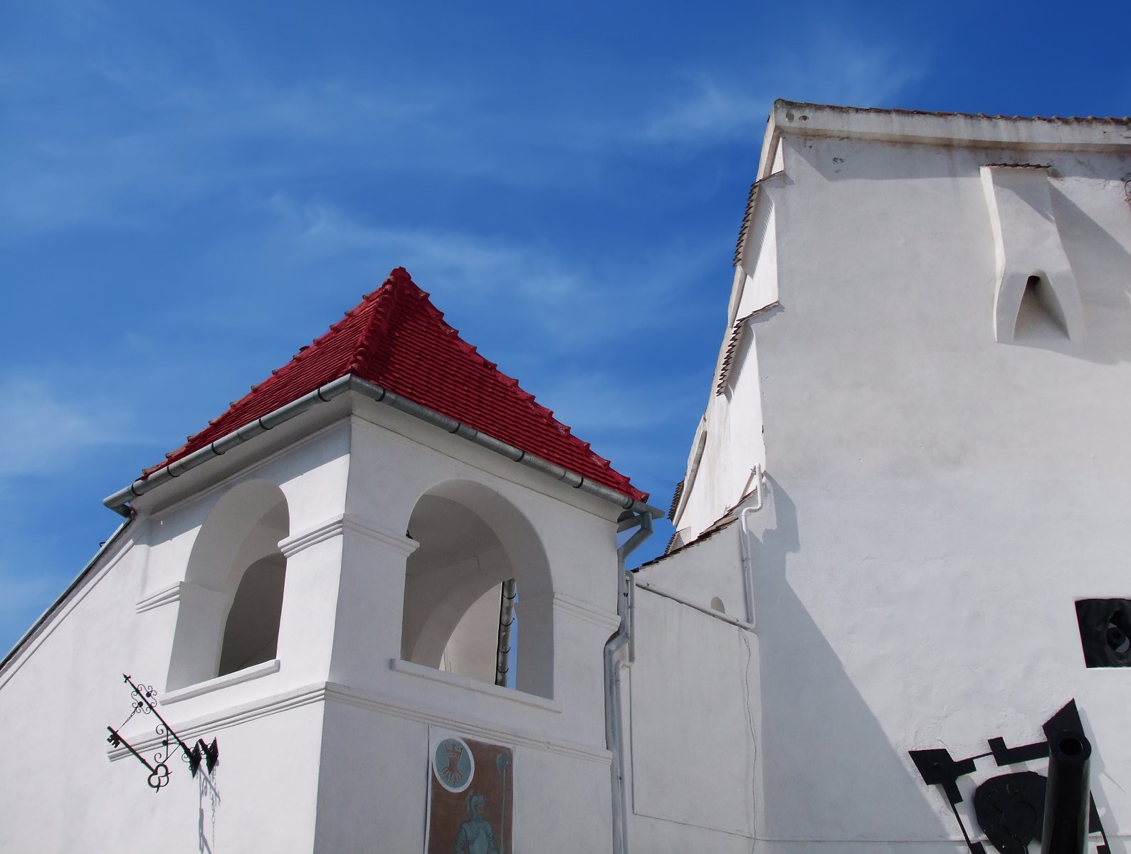 an old church with two large windows and a red roof