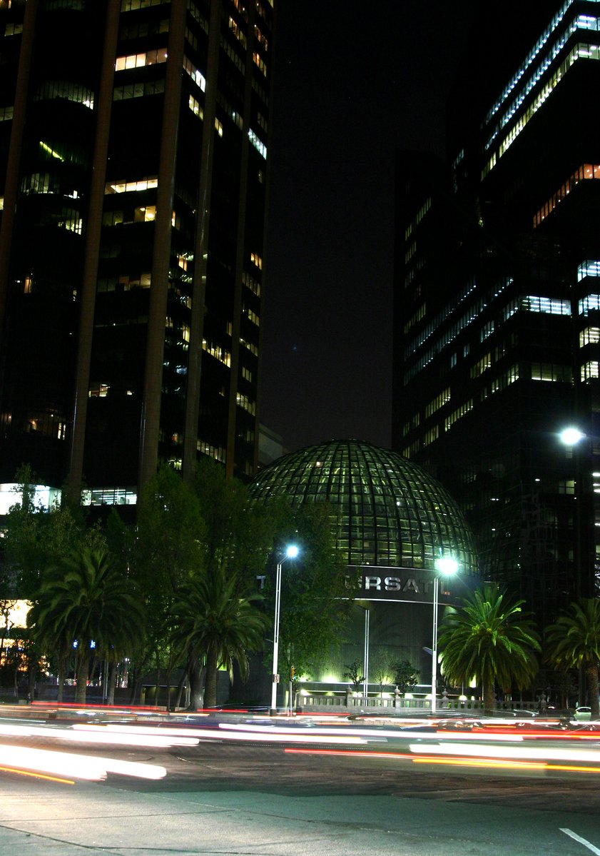 night view of tall buildings, with the lights of cars shining in front