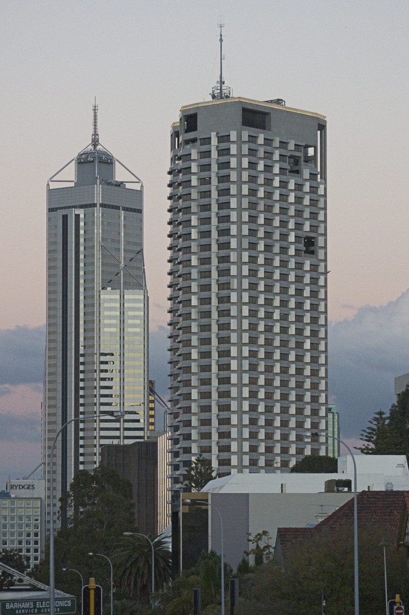 city buildings against the evening sky near a traffic light